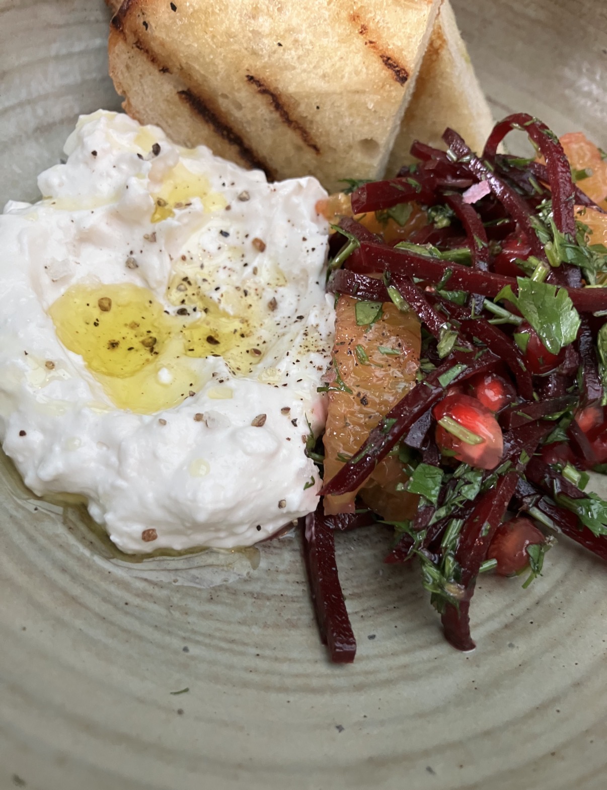Close-up of a vegan dish at Gaucho with grilled bread, beetroot, citrus, pomegranate and herbs