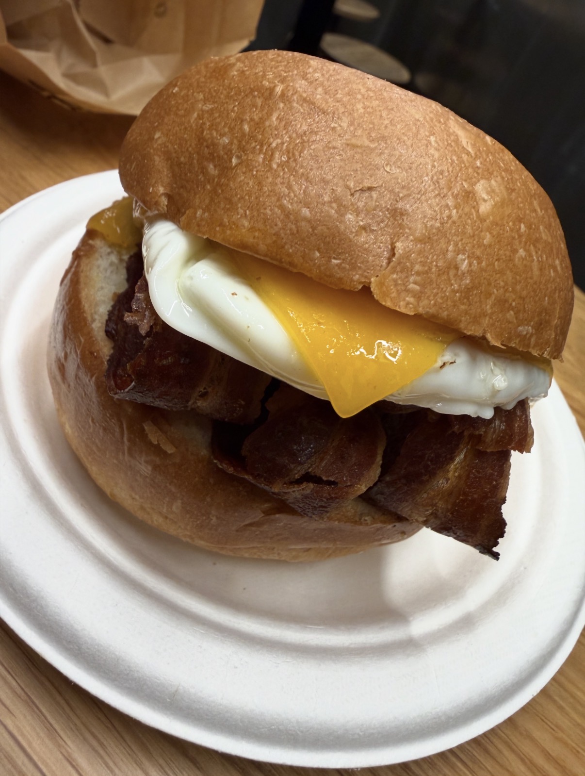 Close-up of an Eggslut bacon, fried egg and cheese sandwich in a brioche bun