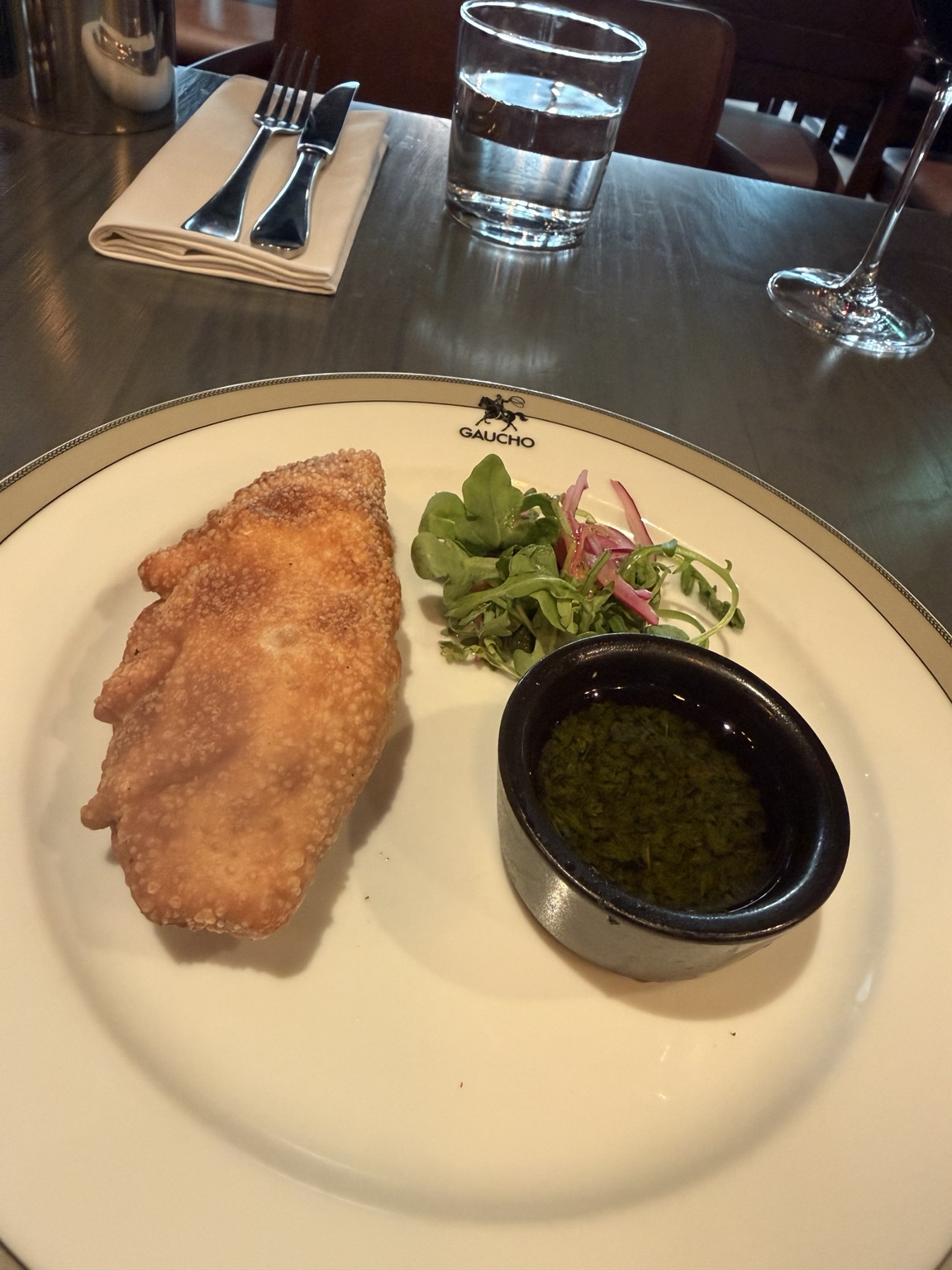 Gaucho Three-Cheese Empanada served with rocket, pickled red onion and chimichurri