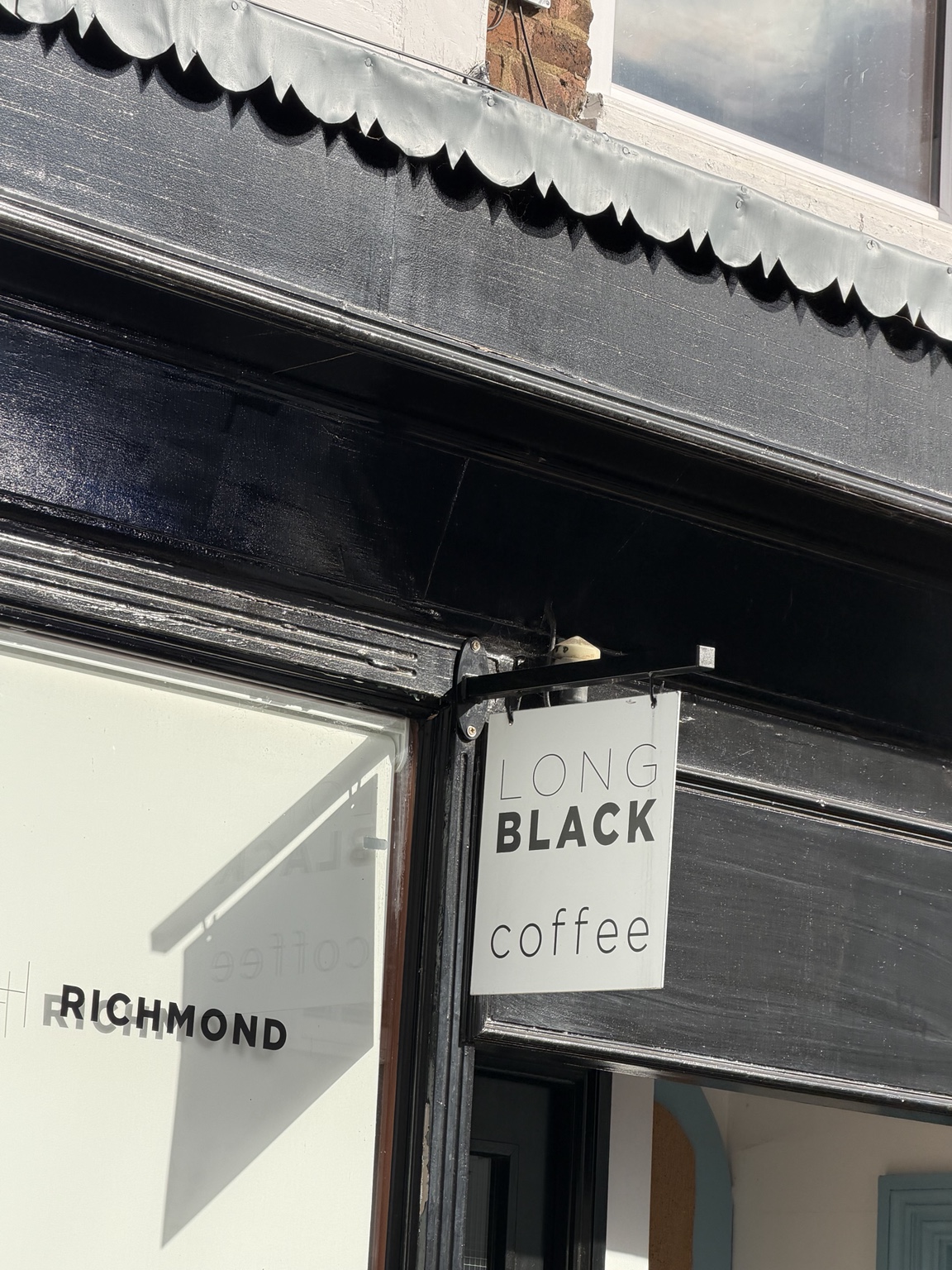 Wider view of the Long Black coffee shop in Richmond, with the word coffee beneath the shop name.